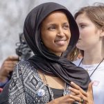 How Is Ilhan Omar Worth Up to $30 MILLION?! Ilhan Omar wearing a black headscarf at an outdoor event
