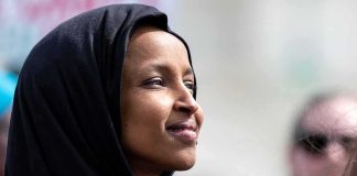 Ilhan Omar Gets FLIRTY With Far-Left Streamer Ilhan Omar in profile wearing a black headscarf outdoors