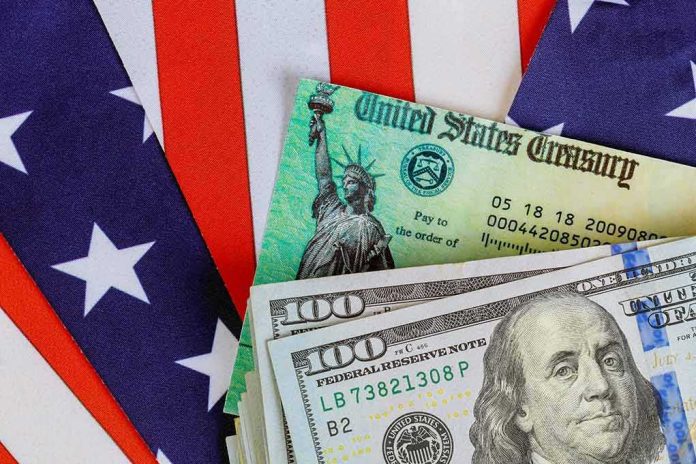 U.S. Treasury check and hundred dollar bills on American flag