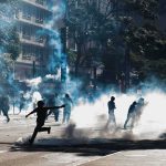 France LOCKS DOWN Its Streets Protesters running through tear gas on a city street