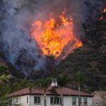 Man Charged With ARSON in 1,000-Acre Wildfire Wildfire burning on a hillside near homes