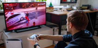 man playing video game on a TV with a controller