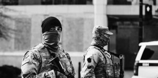 Commandos Wore DISGUISES Inside Kabul Two armed soldiers in tactical gear standing guard on a city street