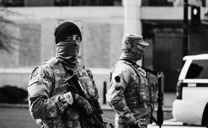 shutterstock_1895086066 Two armed soldiers in tactical gear standing guard on a city street