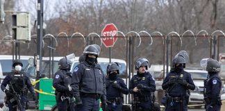 Terror Arrest Follows MYSTERY RAF Base Incident Group of police officers in riot gear standing on a street; Brian Folkerts present