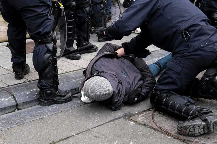 shutterstock_1906428373 police detain person on sidewalk during street incident