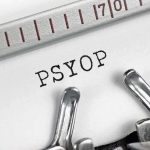Typewriter typing the word PSYOP on white paper