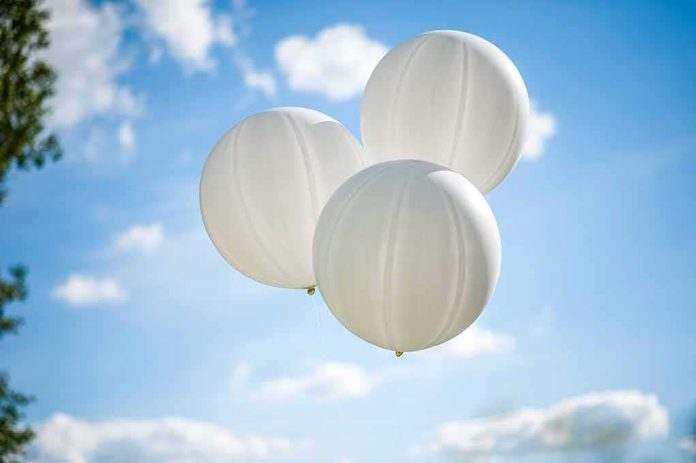 shutterstock_203517373 Three white balloons against a blue sky