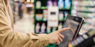 Strong Economy Numbers Hide STRANGE Disconnect Shopper using self-checkout touchscreen in a grocery store