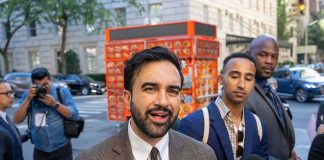 DHS Chief Blames MAMDANI After ICE Shoots Illegal Zohran Mamdani speaking to reporters on a city sidewalk