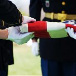 Scammers Target Families Burying U.S. Veterans Military personnel folding a flag during a ceremonial event