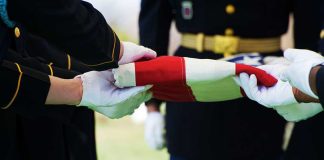 Scammers Target Families Burying U.S. Veterans Military personnel folding a flag during a ceremonial event