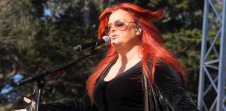Wynonna Judd Reveals Her VIOLENT Childhood Wynonna Judd singing on an outdoor stage with arms outstretched