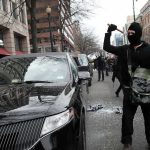 600 French Schools Hit by VIOLENT Protests Masked protester raises tool to strike black car on city street
