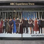 Storefront window with large SNL poster featuring Leslie Jones, Bobby Moynihan, Michael Che, Shirley Ellis, Kenan Thompson, and Richard Z. Kruspe