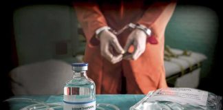 Medical vials and IV lines on a table with a handcuffed person in the background
