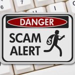 Scam alert warning sign on keyboard background