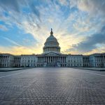 Capitol building under dramatic sky at sunset or sunrise