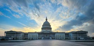 Capitol building under dramatic sky at sunset or sunrise