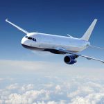 Airplane flying above the clouds in blue sky