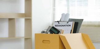 Yellow box with resignation notice on an office desk.