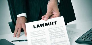 Person holding a document labeled Lawsuit.