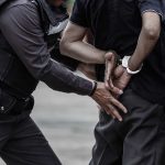 Police officer handcuffing an individual behind their back