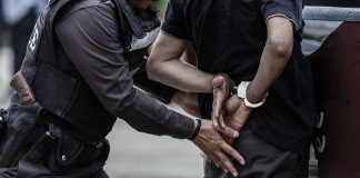 Police officer handcuffing an individual behind their back