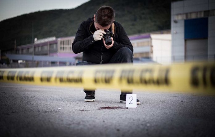 702059647 featured image Person photographing crime scene evidence behind police tape