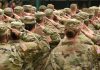 Soldiers in uniform saluting during a ceremony