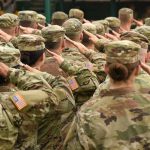 Soldiers in uniform saluting during a ceremony