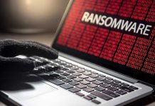 Gloved hand on laptop with ransomware screen