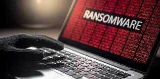 Gloved hand on laptop with ransomware screen