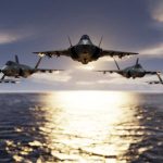 Five jets flying low over the ocean at sunset