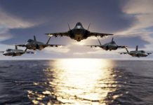 Five jets flying low over the ocean at sunset