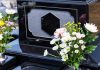 Colorful flowers on a black tombstone.