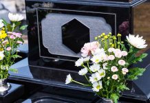 Colorful flowers on a black tombstone.