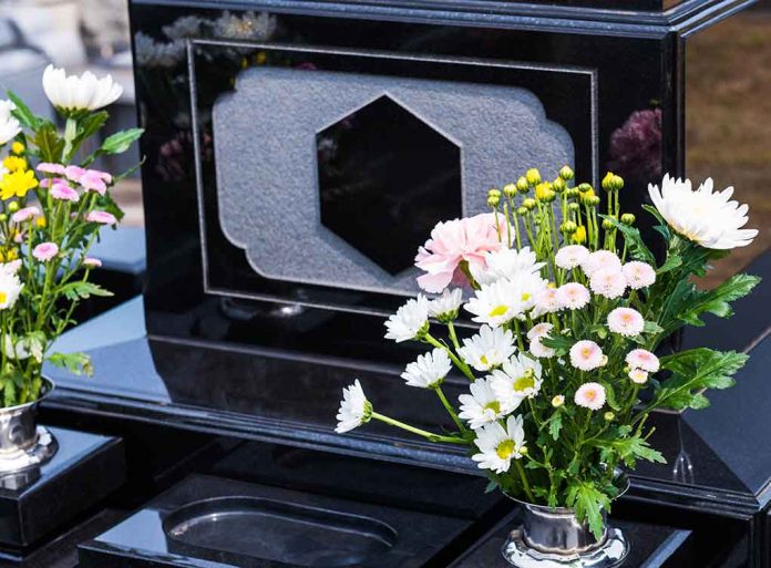 1796581054 featured image Colorful flowers on a black tombstone.