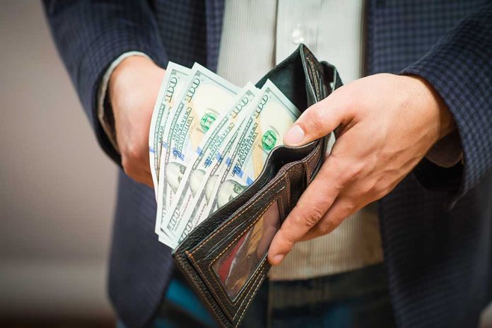 253526959 featured image Hands holding wallet with multiple dollar bills