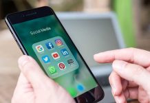 Person holding phone with social media app icons