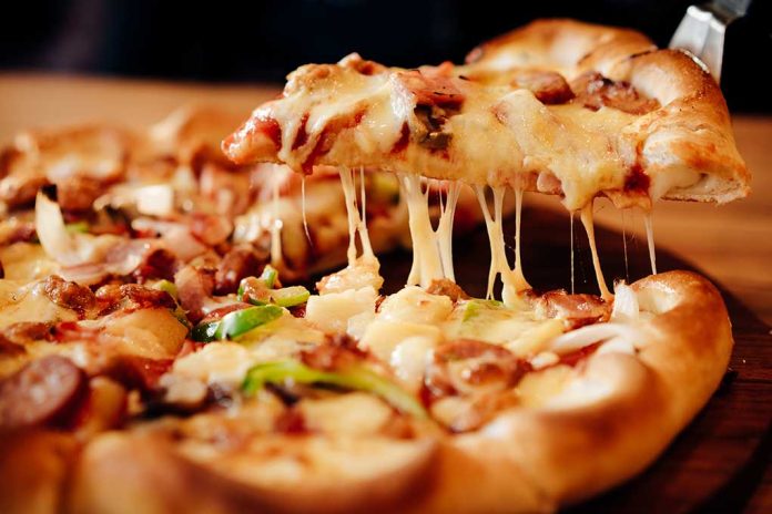 643604302 featured image Cheesy pizza slice being lifted from whole pizza