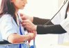 Doctor examining patient with stethoscope in hospital