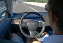 Person in Tesla car using autopilot on highway.