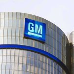 Glass building with large GM logo on top