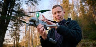 Person holding a drone in a forest