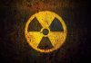 Yellow radiation warning symbol on rusty metal surface