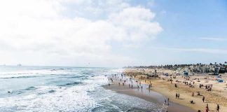 Crowded beach with waves and people enjoying sun