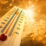 A thermometer displaying temperature against a sunset sky