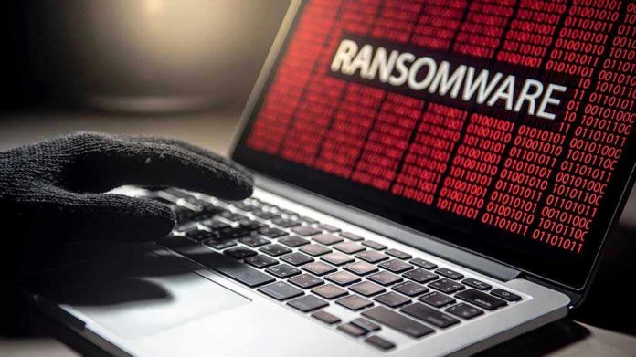 1141202159 Gloved hand on laptop with ransomware screen.