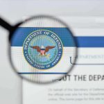 Magnifying glass over Department of Defense logo.